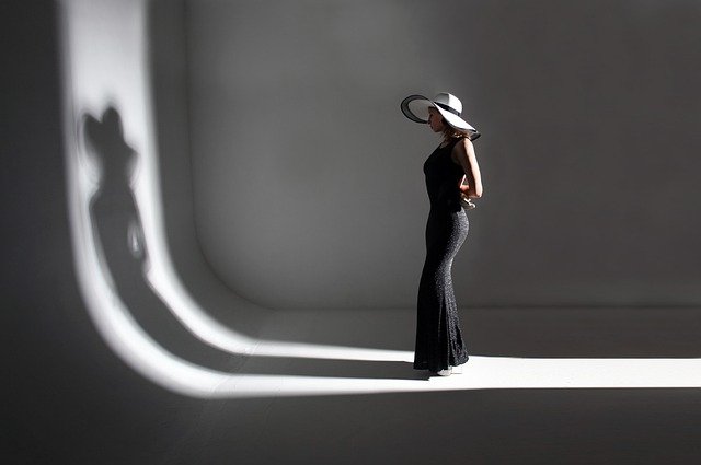 Photo d'une femme en noir et blanc debout avec un chapeau